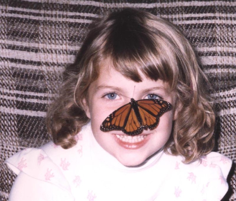 Author Elizabeth Bell at age six with a Monarch butterfly on her nose